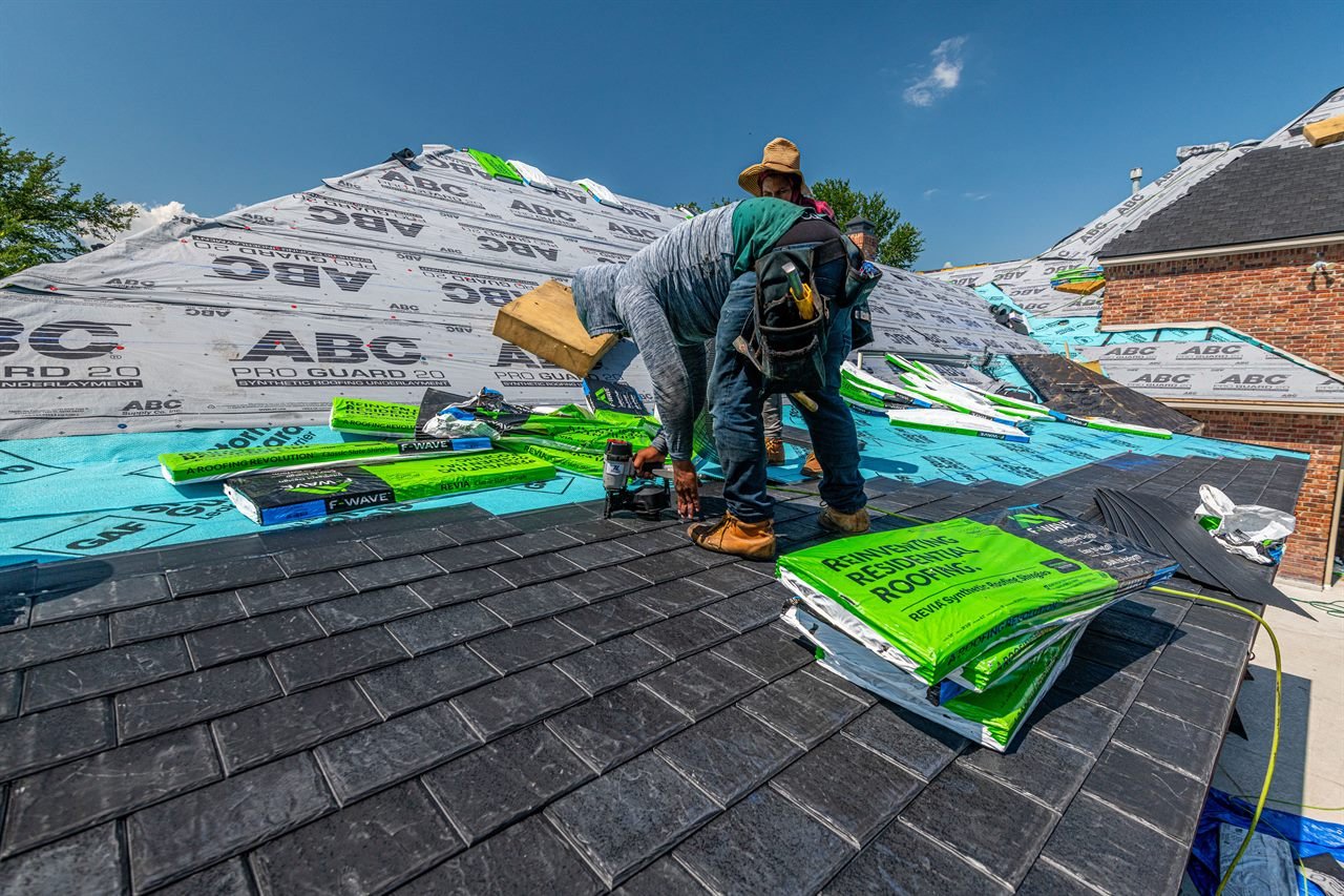 Roofers installing new asphalt shingles on a home in Haverhill, MA
