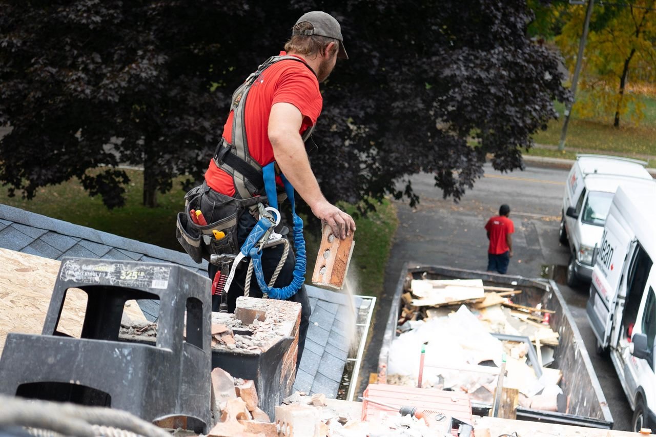 Roofer wearing a safety harness while working on a roof in Haverhill, MA